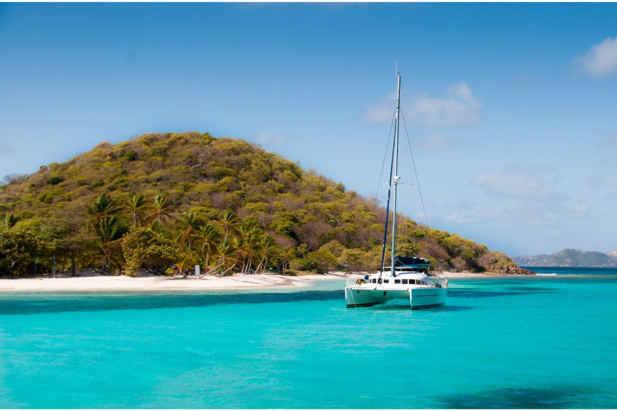 Catamaran in front of island in the caribbean