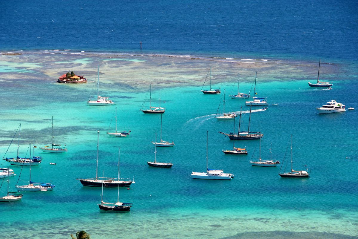 Catamarans and yachts anchored in clear turquoise waters off the coast of Grenada, Caribbean.
