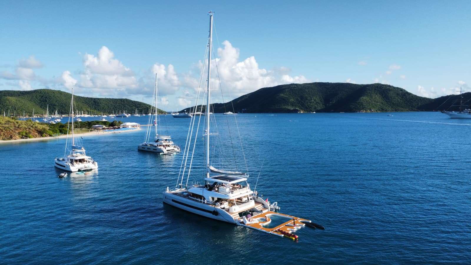 Aerial view of the luxury Lagoon catamaran Triwing Endor anchored in calm blue waters of the British Virgin Islands, surrounded by tropical islands during a private Caribbean yacht charter.